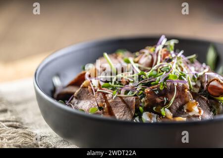 Roastbeef Salat mit Kräutern und Balsamico Soße im Stil einer Schüssel auf einem Restauranttisch - Nahaufnahme. Stockfoto