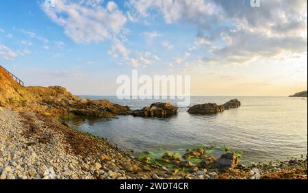 Kieselsteinfelder von bulgarien mit Felsen bei Sonnenaufgang. Wunderschöne Landschaft im Freien mit Blick auf den Horizont unter Wolken am blauen Himmel. Sommer-lei Stockfoto