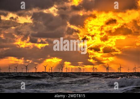 Blick auf den Sonnenuntergang von Walney Island über die Irische See in Richtung der entfernten Walney Offshore Wind Farm, Cumbrian Coast, Cumbria, England, Großbritannien Stockfoto