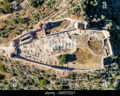 Blick aus der Vogelperspektive auf die mittelalterliche Burgruine Bairen in der Nähe von Gandia in Spanien mit teilweise restaurierten runden Türmen mit bewölktem Himmel Stockfoto