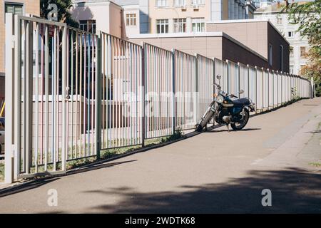 Motorrad in der Nähe eines langen Zauns. Hochwertige Fotos Stockfoto