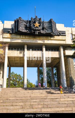 Ein Beispiel für sowjetische, russisch-sozialistische, modernistische Handelsarchitektur. Mit einem großen, bronzenen Siegel, Wappen-Skulptur und goldenem Stern. Beim Militär Stockfoto