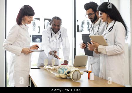 Afrikanischer Männerlehrer, der Universitätsstudenten oder jungen Ärzten Anatomie lehrt. Stockfoto