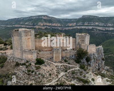 Panoramablick auf das Schloss Chirel auf einem felsigen Felsen, der über die El Jugar-Schlucht in Cortes de Pallas ragt, mit dreieckigem Grundriss und Pfeilschlitzen Stockfoto