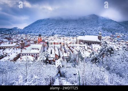 Brasov, Siebenbürgen. Winterlandschaft mit Ratsplatz, Schwarzer Kirche und Karpaten, Winterreisen in Rumänien. Stockfoto