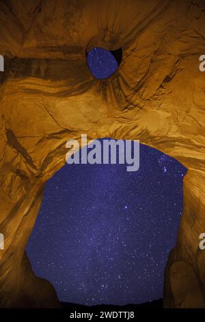 Die Milchstraße durch den Big Hogan Arch bei Nacht im Monument Valley Navajo Tribal Park in Arizona. Stockfoto