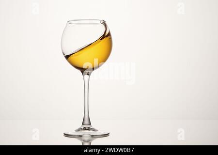 Weißwein, diagonale Welle, Curl ist in stielförmigem Glas. Stockfoto