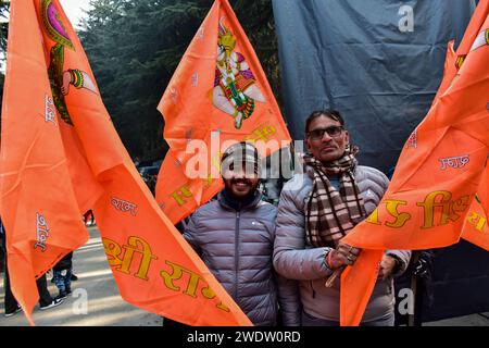 Hindugeweihte halten religiöse Fahnen, wenn sie am Shankaracharya Tempel ankommen, um Rituale anlässlich der Einweihungszeremonie des Ayodhya RAM Tempels durchzuführen. Premierminister Narendra Modi hat am Montagnachmittag die "Pran pratishtha" oder die Weihe des RAM-Tempels in Ayodhya abgeschlossen. Die besondere Zeremonie für den Tempel, der sich noch im Bau befindet, war eine jahrzehntelange Anstrengung. Für Hindus ist der Ort der Geburtsort von Lord RAM, einer der verehrtesten Gottheiten im hinduistischen Glauben. Aber die Stätte wird auch von Muslimen verehrt, weil sie einst den Babri Mosqu aus dem 16. Jahrhundert beherbergt hatte Stockfoto