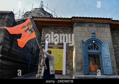 Ein Hindugeweihter hält eine religiöse Flagge am Shankaracharya Tempel anlässlich der Einweihungszeremonie des Ayodhya RAM Tempels. Premierminister Narendra Modi hat am Montagnachmittag die "Pran pratishtha" oder die Weihe des RAM-Tempels in Ayodhya abgeschlossen. Die besondere Zeremonie für den Tempel, der sich noch im Bau befindet, war eine jahrzehntelange Anstrengung. Für Hindus ist der Ort der Geburtsort von Lord RAM, einer der verehrtesten Gottheiten im hinduistischen Glauben. Aber die Stätte wird auch von Muslimen verehrt, weil sie einst die Babri-Moschee aus dem 16. Jahrhundert beherbergt hat, ein Glaubensdenkmal für Indi Stockfoto