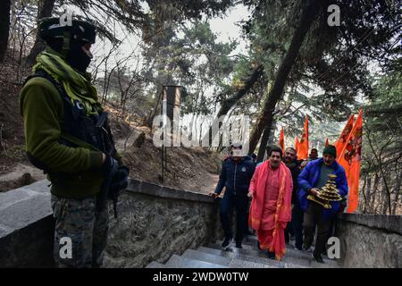 Ein indischer paramilitärischer Soldat wacht auf, als hinduistische Anhänger anläßlich der Einweihungszeremonie des Tempels Ayodhya RAM Rituale im Tempel von Shankaracharya durchführen. Premierminister Narendra Modi hat am Montagnachmittag die "Pran pratishtha" oder die Weihe des RAM-Tempels in Ayodhya abgeschlossen. Die besondere Zeremonie für den Tempel, der sich noch im Bau befindet, war eine jahrzehntelange Anstrengung. Für Hindus ist der Ort der Geburtsort von Lord RAM, einer der verehrtesten Gottheiten im hinduistischen Glauben. Aber die Stätte wird auch von Muslimen verehrt, weil sie einst das 16. Jahrhundert beherbergt hat Stockfoto