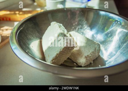 Weiße Hüttenkäsewürfel in einer Aluminiumschale, Ergänzungen zu kulinarischen Gerichten Stockfoto