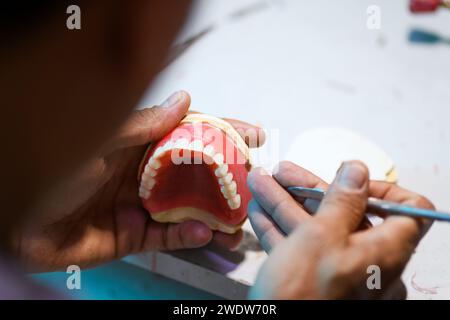 Nahaufnahme der prothetischen Handwerkskunst, die die Detailarbeit zur Herstellung einer Zahnprothese zeigt Stockfoto