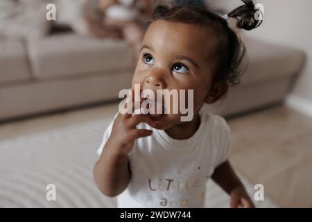 Porträt eines Kleinkindermädchens mit gemischter Rasse im Zimmer. Afrokaukasisches kleines Mädchen. Das Konzept der interrassischen Familie. Stockfoto