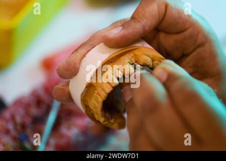 Nahaufnahme der prothetischen Handwerkskunst, die die Detailarbeit zur Herstellung einer Zahnprothese zeigt Stockfoto