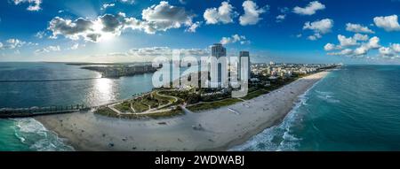 Blick aus der Vogelperspektive auf den South Pointe Park in Miami mit luxuriösen Wohnungstürmen, Sandstrand, Government Cut Waterway, um Kreuzfahrtschiffverkehr zu transportieren Stockfoto