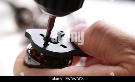 Festziehen der Schrauben in das Kohlegehäuse des fpv-DIY-Copters Stockfoto