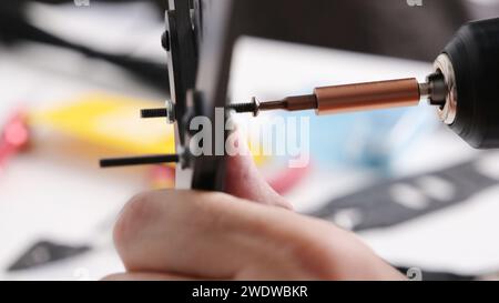 Festziehen der Schrauben in das Kohlegehäuse des fpv-DIY-Copters, Nahansicht Stockfoto