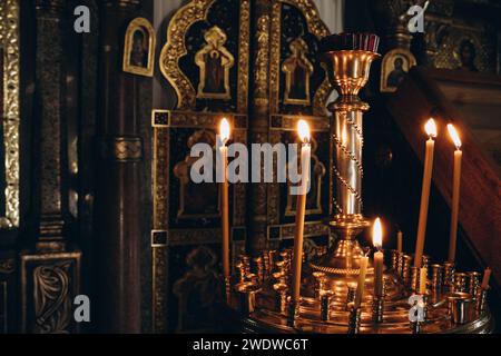 Kerzen auf einem Kerzenhalter in einer Kirche, warmes Licht. Hochwertige Fotos Stockfoto