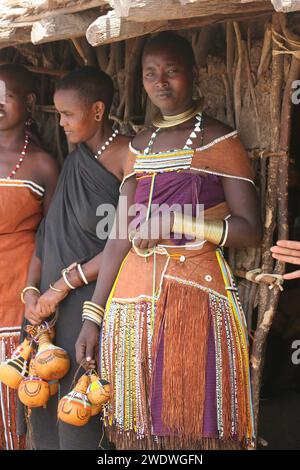 Datoga Frauen in traditionellem Kleid Perlen und Ohrringe vor einer Holzhütte fotografiert in Tansania Stockfoto