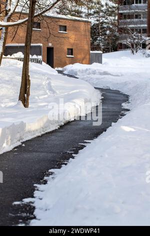 Winterstraße frei von Schnee: Salz, das verwendet wird, um Schnee auf Gehwegen in der Nähe von Häusern zu schmelzen. Stockfoto