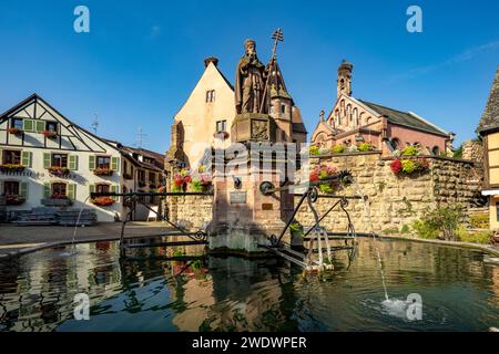 Fontaine de Saint-Léon und St. Leo-Kapelle in Eguisheim, Elsass, Frankreich Stockfoto