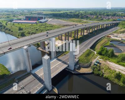 Aus der Vogelperspektive auf dem Barton Viaduct über die Autobahn M60 mit Salford Western Gateway Liftbrücke über den Manchester Ship Canal und das AJ Bell Stadion Stockfoto