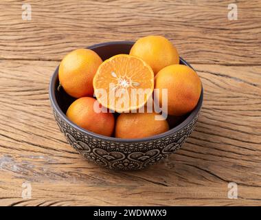 Cravo oder RosenZitronen in einer Schüssel über einem Holztisch. Stockfoto