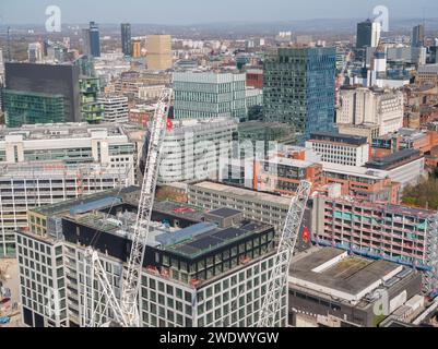 Luftaufnahme von Turmkränen und Bauarbeiten am Manchester Goods Yard mit Spinningfields im Stadtzentrum von Manchester, Großbritannien im Hintergrund Stockfoto