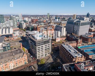 Luftaufnahme des Barbirolli Square, des St. Peter's Square und des größeren Stadtzentrums von Manchester, Großbritannien mit schneebedeckten Pennines in der Ferne an einem sonnigen Tag Stockfoto