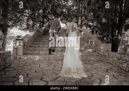 Verheiratete Paare gehen weg, Braut und Bräutigam feiern ihren Hochzeitstag, Braut blickt zurück Stockfoto