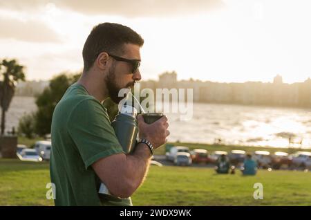 Mann trinkt Chimarrao, Mate (eine Infusion von Yerba Mate mit heißem Wasser) bei Sonnenuntergang in uruguay Stockfoto