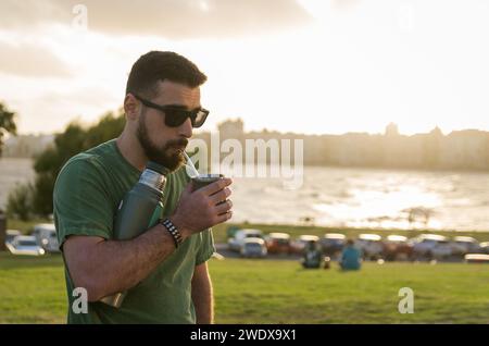 Mann trinkt Chimarrao, Mate (eine Infusion von Yerba Mate mit heißem Wasser) bei Sonnenuntergang in uruguay Stockfoto