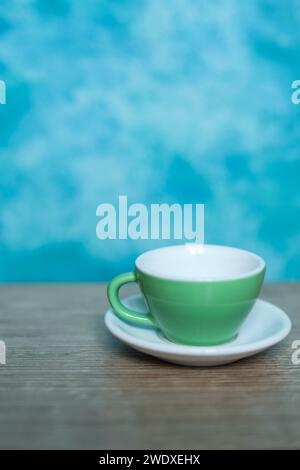 Grüne Kaffeetasse auf blauem Hintergrund. Minimalismus. Stockfoto