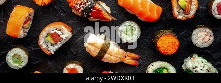 Sushi-Panorama. Eine Auswahl an Rollen, Maki, Nigiri usw., Flachbild-Lay-Shot auf schwarzem Hintergrund. Japanisches Restaurant Stockfoto