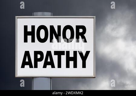 Nahaufnahme auf einer gelben Werbetafel vor einem bewölkten Himmel mit der Aufschrift „Honor Apathy“ in der Mitte. Stockfoto
