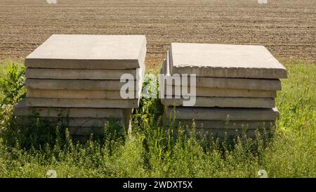 Betonplatten auf dem Feld sind in zwei Stapeln gestapelt Stockfoto