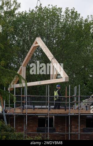 Dachträger, die mit einem Kran auf einer Baustelle eines Wohngebäudes installiert werden Stockfoto