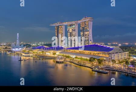 Luftaufnahme der Stadt Singapur bei Sonnenuntergang. Landschaft der Marina Bay von Singapur mit modernen Gebäuden und Wolkenkratzern bei Nacht Stockfoto