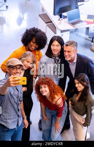 Verschiedene Geschäftsleute machen gemeinsam ein Selfie im Büro. Geschäfts- und Technologiekonzept. Stockfoto