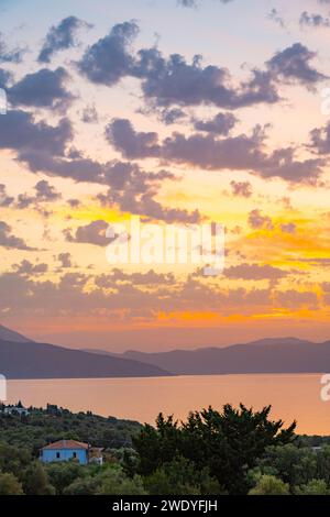 Sonnenaufgang hinter den Bergen des griechischen Festlandes von der Insel Meganisi im Ionischen Meer Stockfoto