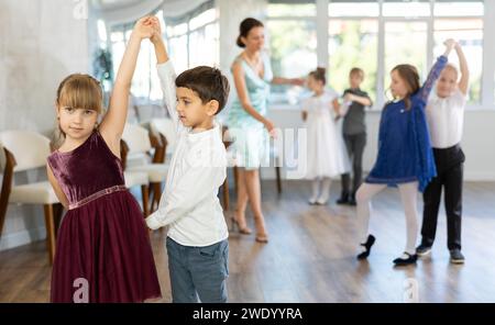 Tween Mädchen und Jungs tanzen langsamen Partnertanz während festlicher Veranstaltung Stockfoto