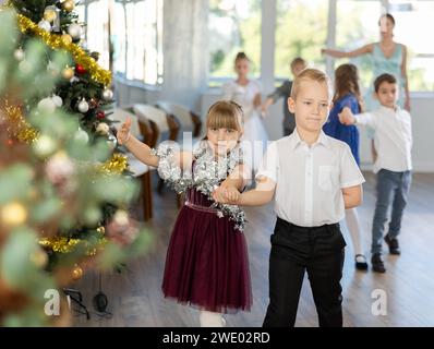 Jugendliche in eleganten Outfits üben im Weihnachtsstudio Partnertanz Stockfoto