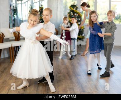 Tween Junge und Mädchen spielen Walzer während der Weihnachtsfeier in der Schule Stockfoto