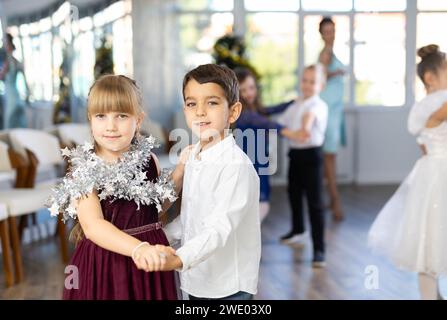 Jugendliche in eleganten Outfits üben im Weihnachtsstudio Partnertanz Stockfoto