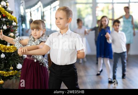 Tween Junge und Mädchen spielen Walzer während der Weihnachtsfeier in der Schule Stockfoto