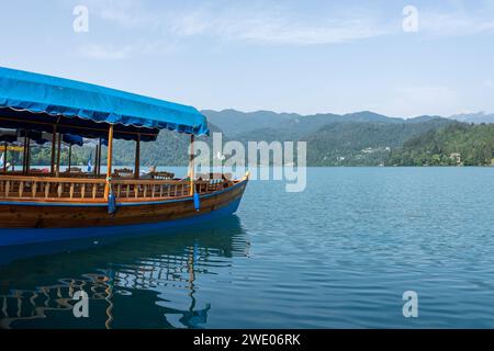 Traditionelles Pletna am Ufer des Bleder Sees mit den Alpen im Hintergrund, Slowenien Stockfoto