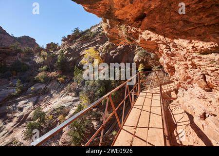 Eine Promenade schlängelt sich um einen steilen Felsüberhang, während der Weg weiter zum Canyon Overlook führt. Es ist ein sehr beliebter Wanderweg im zion-Nationalpark Stockfoto