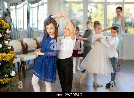 Jugendliche in eleganten Outfits üben im Weihnachtsstudio Partnertanz Stockfoto