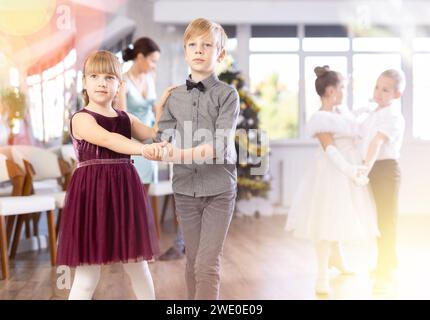 Jugendliche in eleganten Outfits üben im Weihnachtsstudio Partnertanz Stockfoto
