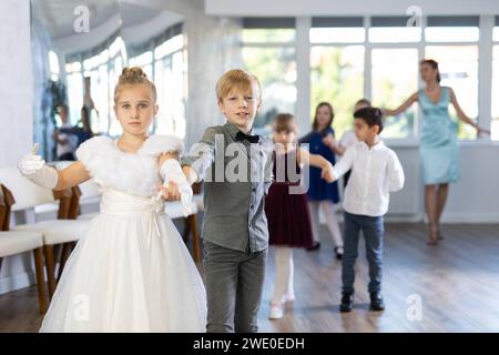 Tween Mädchen und Jungs tanzen langsamen Partnertanz während festlicher Veranstaltung Stockfoto